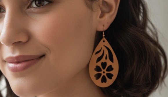 23 Laser Cut Wood Jewelry Ideas 3 Close-up of a woman wearing a laser cut wood jewelry earring with floral and heart cutout design