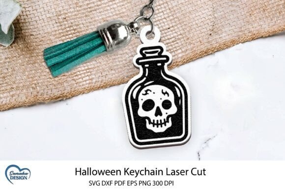 Halloween laser cut keychain bottle Halloween laser cut keychain with engraved bottle and skull motif attached to a green tassel keyring