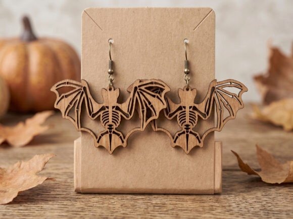 35 Halloween Laser Cut Wood Earrings Ideas 15 Halloween laser cut wood earrings shaped like bats with skeleton designs on a display stand