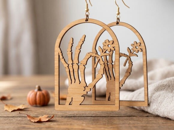 35 Halloween Laser Cut Wood Earrings Ideas 16 Halloween laser cut wood earrings with skeleton hand holding flowers design on wooden table