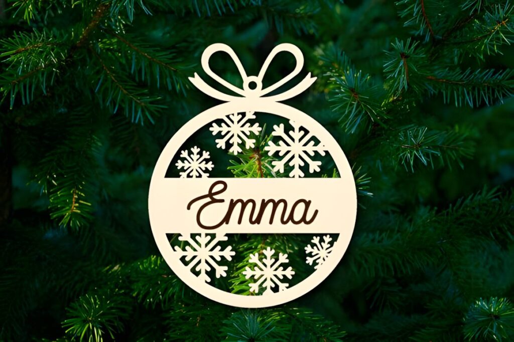 54 Christmas Laser Cut Files for Festive Laser Projects 11 Christmas Laser Cut Files wooden ornament with snowflakes and name Emma hanging on green pine tree