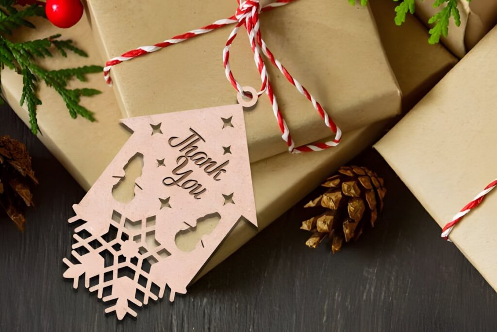 54 Christmas Laser Cut Files for Festive Laser Projects 33 Christmas Laser Cut Files wooden gift tag with Thank You text and snowflake design tied to wrapped present with red and