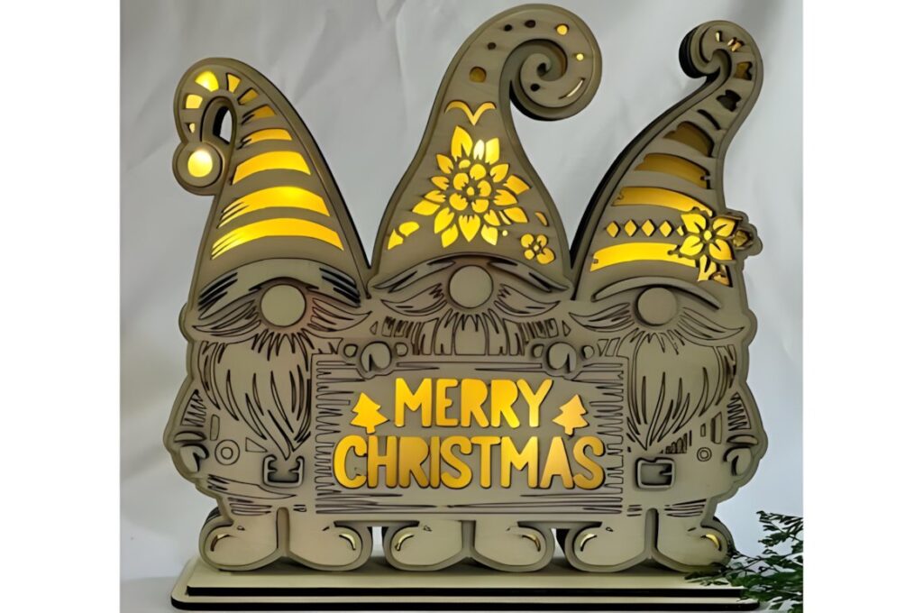 54 Christmas Laser Cut Files for Festive Laser Projects 61 Christmas Laser Cut Files showing three layered gnomes with illuminated hats and a Merry Christmas sign